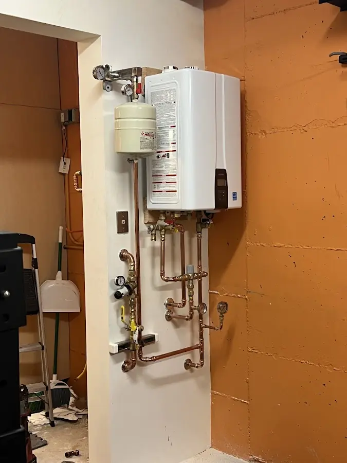 Plumbing technician inspecting water heater connections in Matteson